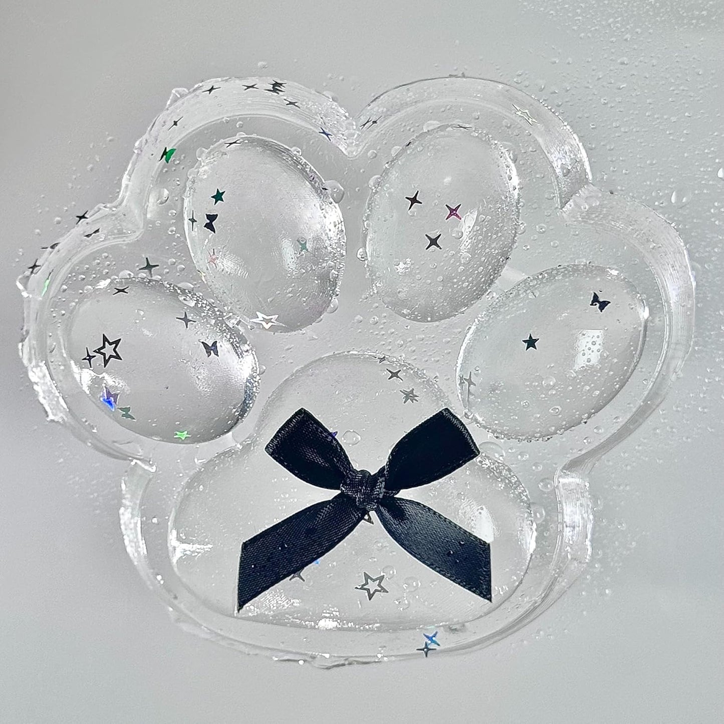 Clear jelly cat paw squishy with black bow and stars
