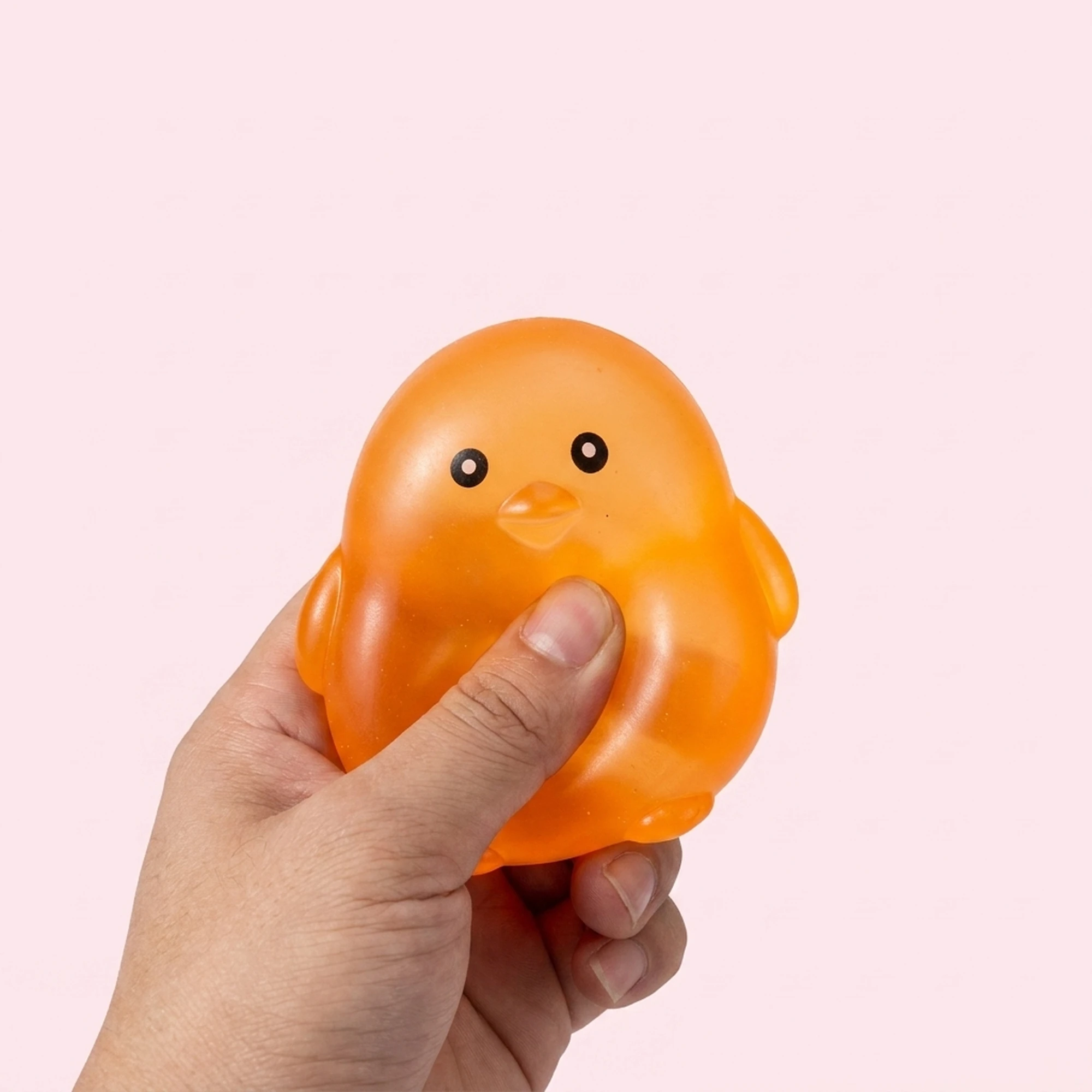 Orange chick squishy ball on a pale pink background
