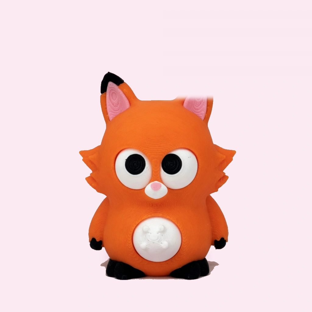 Big-eyed orange fox squishy squeeze toy on a desk