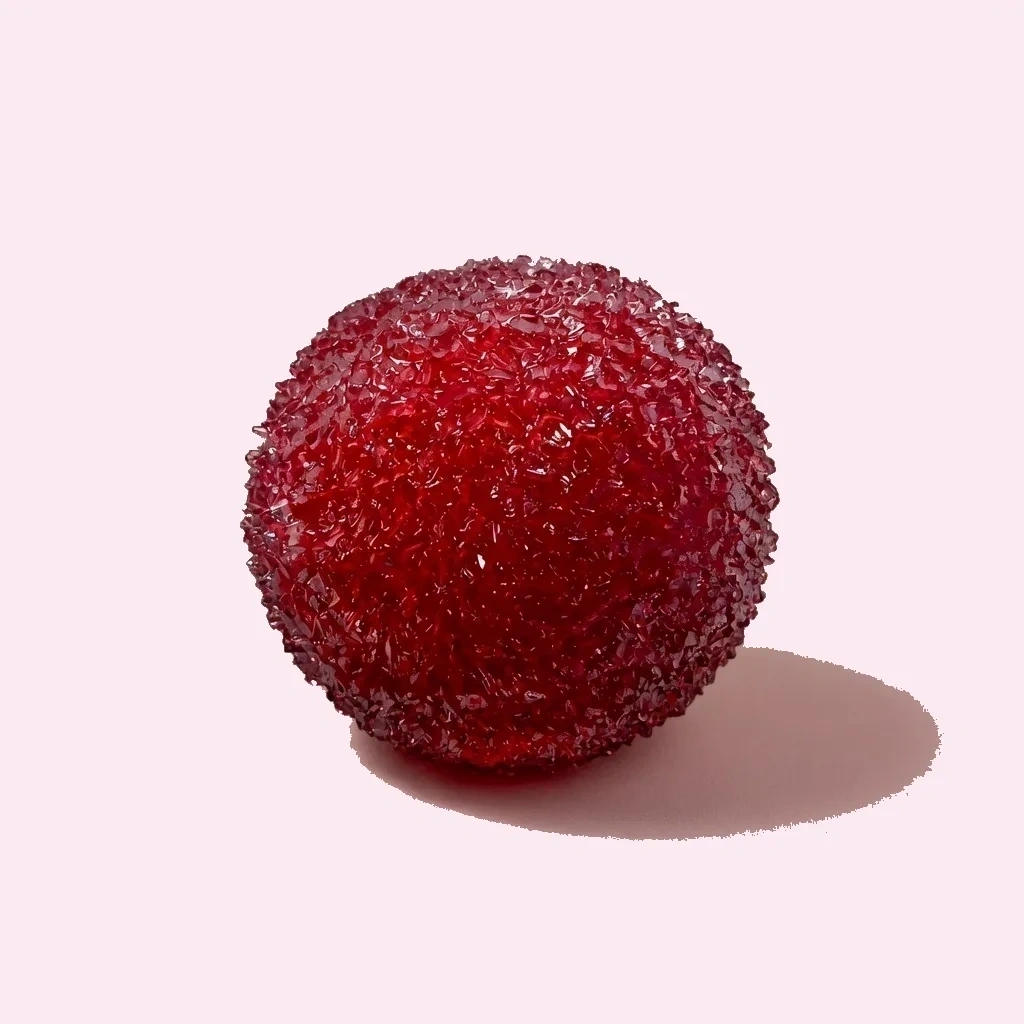 Glossy translucent red cherry-shaped ball with small red pieces visible inside
